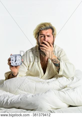 Good Morning. Exhausted Man Being Awakened By Alarm Clock In Bedroom. Mature Man On Bed Turning Off 