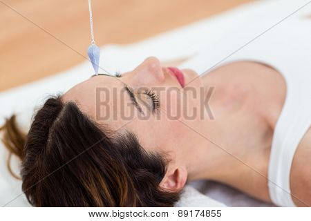 Woman being hypnotized while lying on the wooden floor