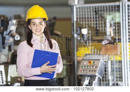 Mechanical engineer standing with a clipboard at metallurgy factory