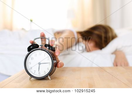 Sleepy Young Woman Trying Kill Alarm Clock