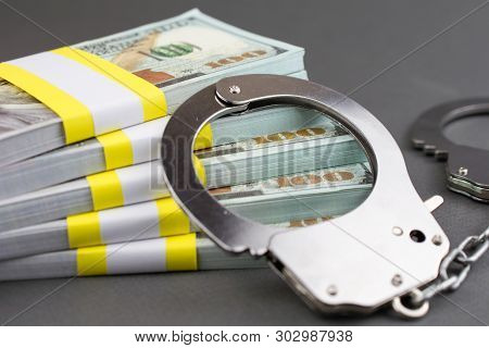 Money And Handcuffs. Financial Crime, Advance Fee Scams, Card Fraud, Counterfeit Cards, Fake Check S