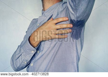 Man With Hyperhidrosis Sweating Very Badly Under Armpit In Blue Shirt. Wet Spot On My Shirt From Swe