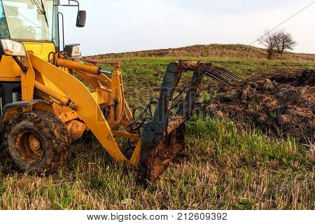 Dredger with natural manure loading trailer for field fertilization. Agricultural machine for fertilizing. Cow Dung