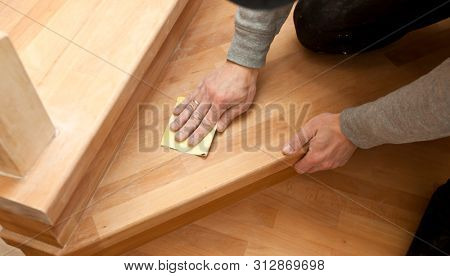 Wood grinding process by sandpaper. The young carpenter works with wood 