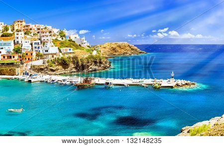 Harbour with marine vessels boats and lighthouse. Panoramic view from a cliff on a Bay with a beach and architecture Bali - vacation destination resort with secluded beaches and clear turquoise ocean waters Rethymno Crete Greece