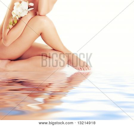 Female legs with white orchid