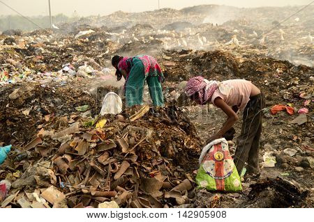 AMRAVATI, MAHARASHTRA, INDIA - APRIL 09, 2014: Unidentified people looking for something in the garbage at Big garbage land. Land and air pollution in India on April 09, 2014, Amravati, India.