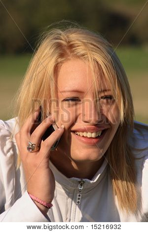 Enjoyable conversation for a teenager on a mobile phone with countryside in the background.