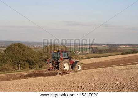 Tractor working on a field preparing the soil for planting.