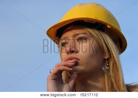 Young female architect apprentice with yellow hard hat.