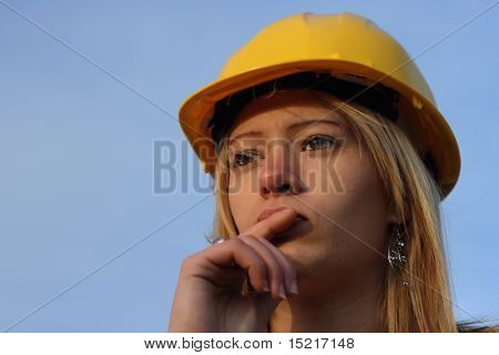 Young female architect apprentice with yellow hard hat.