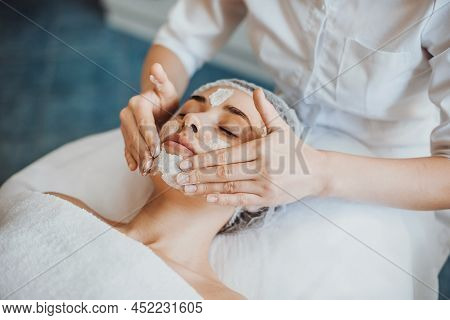 Beautiful Woman Receiving Facial Massage And Spa Treatment At Beauty Salon. Cosmetology Beauty Proce