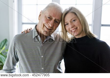 Daughter With Senior Father At Home Close To A Window