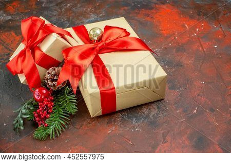 Bottom View Xmas Gifts Tied With Red Ribbon Xmas Tree Branch On Dark Red Table