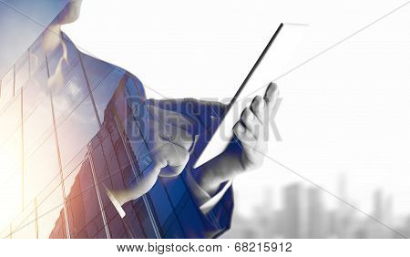 Double exposure of city and business man using digital tablet