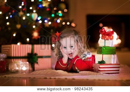 Kids Opening Christmas Presents At Fireplace