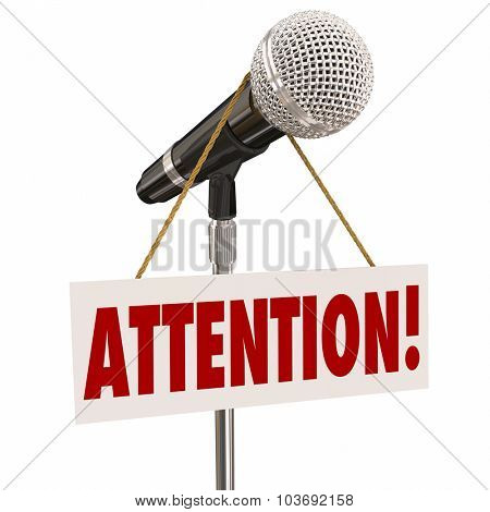 Attention word on a hnaging sign over a microphone urging you to listen or hear an important announcement, news or speech