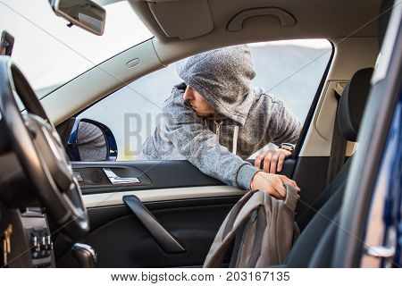 A Thief, A Criminal, Thrust His Hand Out Of The Car Window And Takes A Backpack, Steals Private Prop