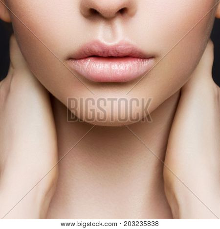 Sexual full lips. Natural gloss of lips and woman's skin. The mouth is closed. Increase in lips cosmetology. Pink lips and long neck.