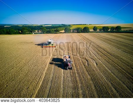 Aerial View On Combine Harvester Gathers The Wheat At Sunset. Harvesting Grain Field, Crop Season. V