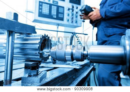 Man operating CNC drilling and boring machine in workshop. Industry, industrial concept.