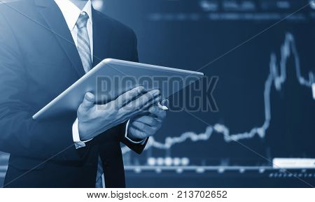 Businessman using digital tablet, raising graph background. Business growth, investment and invest in stock exchange market