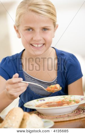 Young Girl Indoors Eating Soup Smiling