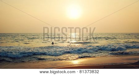 A Few Tourists On The Tropical Ocean Beach - Retro Effect. Sunset In Varkala, India.