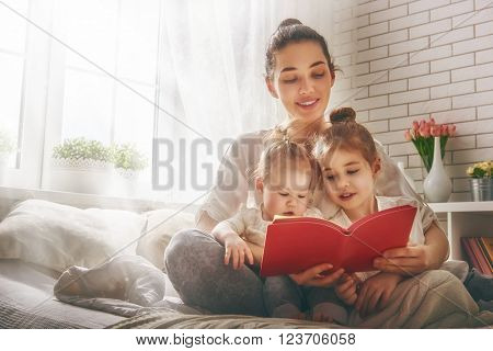 Funny family Mother and her child daughter girl with a paper accessories. Mother and daughter preparing for a party and having fun. Beautiful young woman and funny girl with a paper mustache on stick.