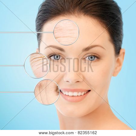 people, skin care and beauty concept - face of beautiful happy young woman over blue background