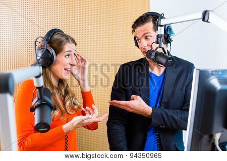 Presenters or moderators - man and woman - in radio station hosting show for radio live in Studio