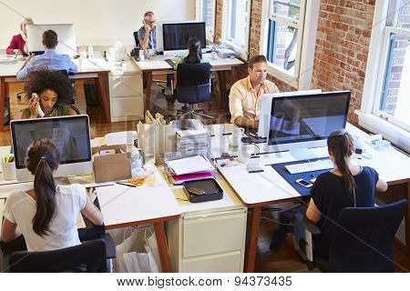 Wide Angle View Of Busy Design Office With Workers At Desks