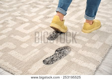 Person In Dirty Shoes Leaving Muddy Footprints On Carpet