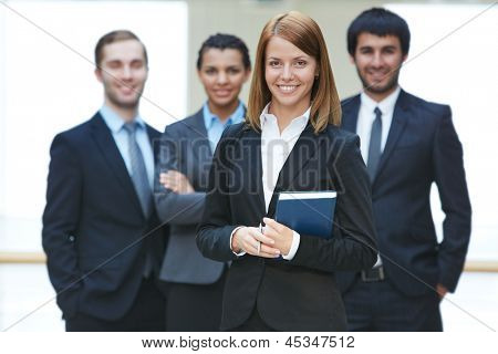 Group of friendly businesspeople with happy female leader in front