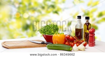 cooking, still life, food and healthy eating concept - fresh ripe vegetables, spices and kitchenware on table over green background