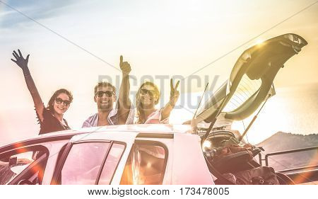 Group of best friends cheering on car road trip at sunset - Happy people outdoor on vacation tour adventure - Friendship concept at travel together around world - Soft focus with vintage color filter