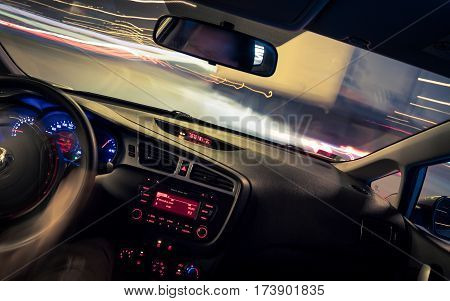 Night driving view from inside car city and other cars light is motion blurred.