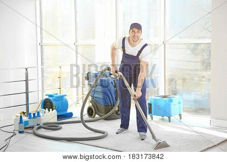 Dry cleaner's employee removing dirt from carpet in flat