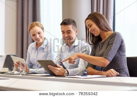 business, people and technology concept - smiling business team with tablet pc computer meeting in office