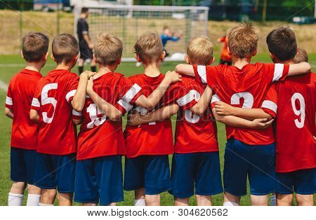 Youth European Football Team In Red Shirts. Young Boys Of Soccer Club On The Stadium During Final Co