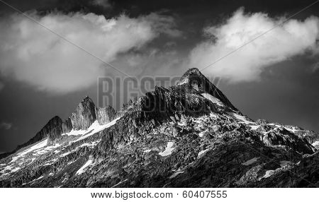 Black and white photo of majestic mountainous landscape, dramatic cloudy sky, beautiful panorama, extreme adventure and traveling concept