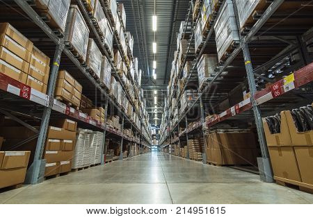 Large warehouse logistic or distribution center. Interior of warehouse with rows of shelves with big boxes