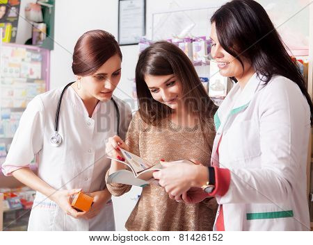 Doctor And Pharmacist Showing Catalog To Client