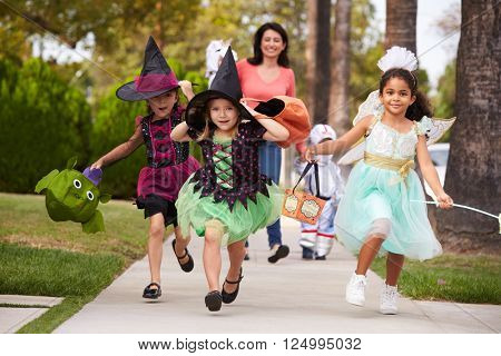 Parent Taking Children Trick Or Treating At Halloween