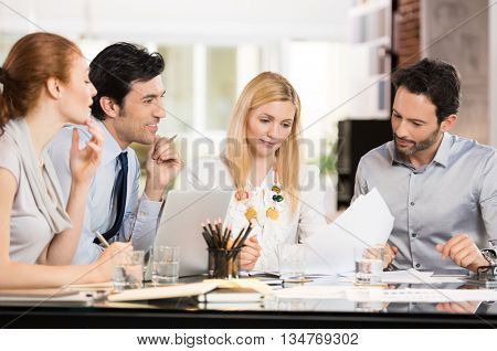 Young businesspeople in a meeting discussing about future strategies. Businessmen and businesswomen discussing the benefits of joint venture. Business teamwork working together in a modern office.