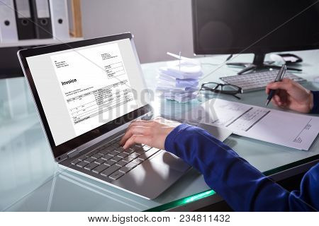 Businessperson Checking Invoice On Laptop