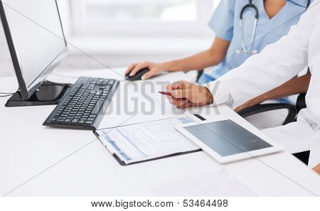 healthcare, medical and technology concept -  group of doctors looking at tablet pc