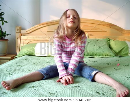 Young girl sitting on a bed