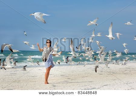 Young beautiful woman watching the seagulls flying