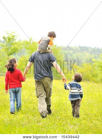 lykkelig familie i naturen, far og børnene gå